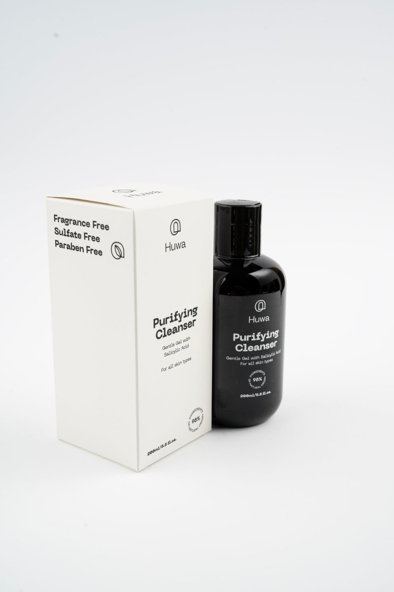 Side view of Box and bottle of huwa skincare purifying cleanser with salicylic acid stating that it is fragrance free and sulfate free and paraben free