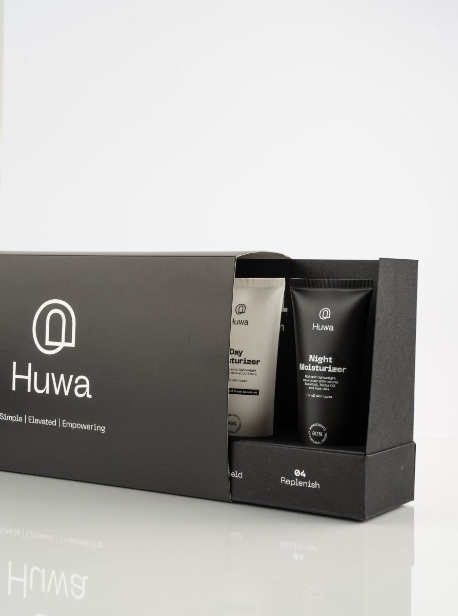 Set of skincare products including day moisturizer and night moisturizer in a barely opened black box with the huwa skincare logo and brand mark 