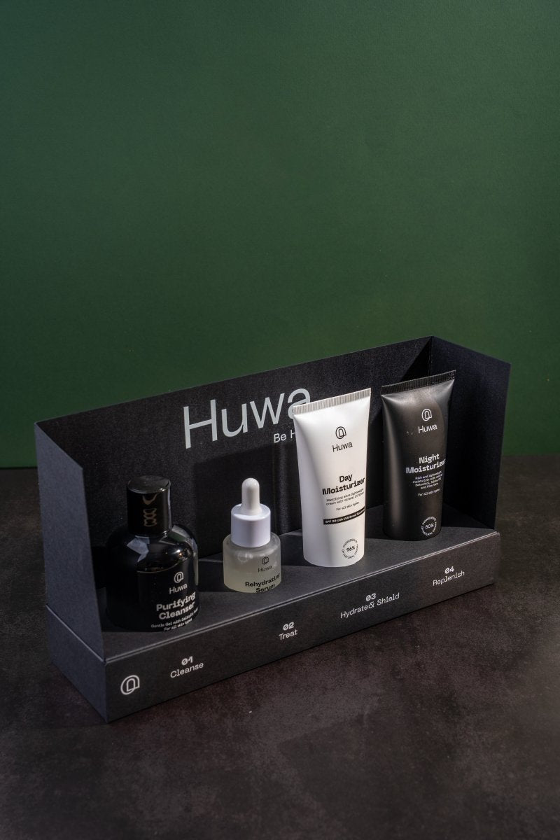 Set of skincare products including  a cleanser and day moisturizer and night moisturizer and a serum in an open black box for a healthier face